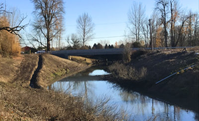 view of Dairy Creek on Sauvie Island, Oregon with a road bridge in the background 