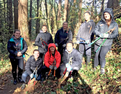 Members of the Lewis & Clark women's softball team pull ivy in George Himes Park (November, 2016).
