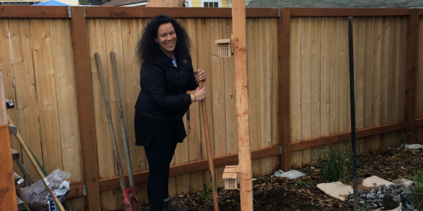 woman with tall wood post in front of fence