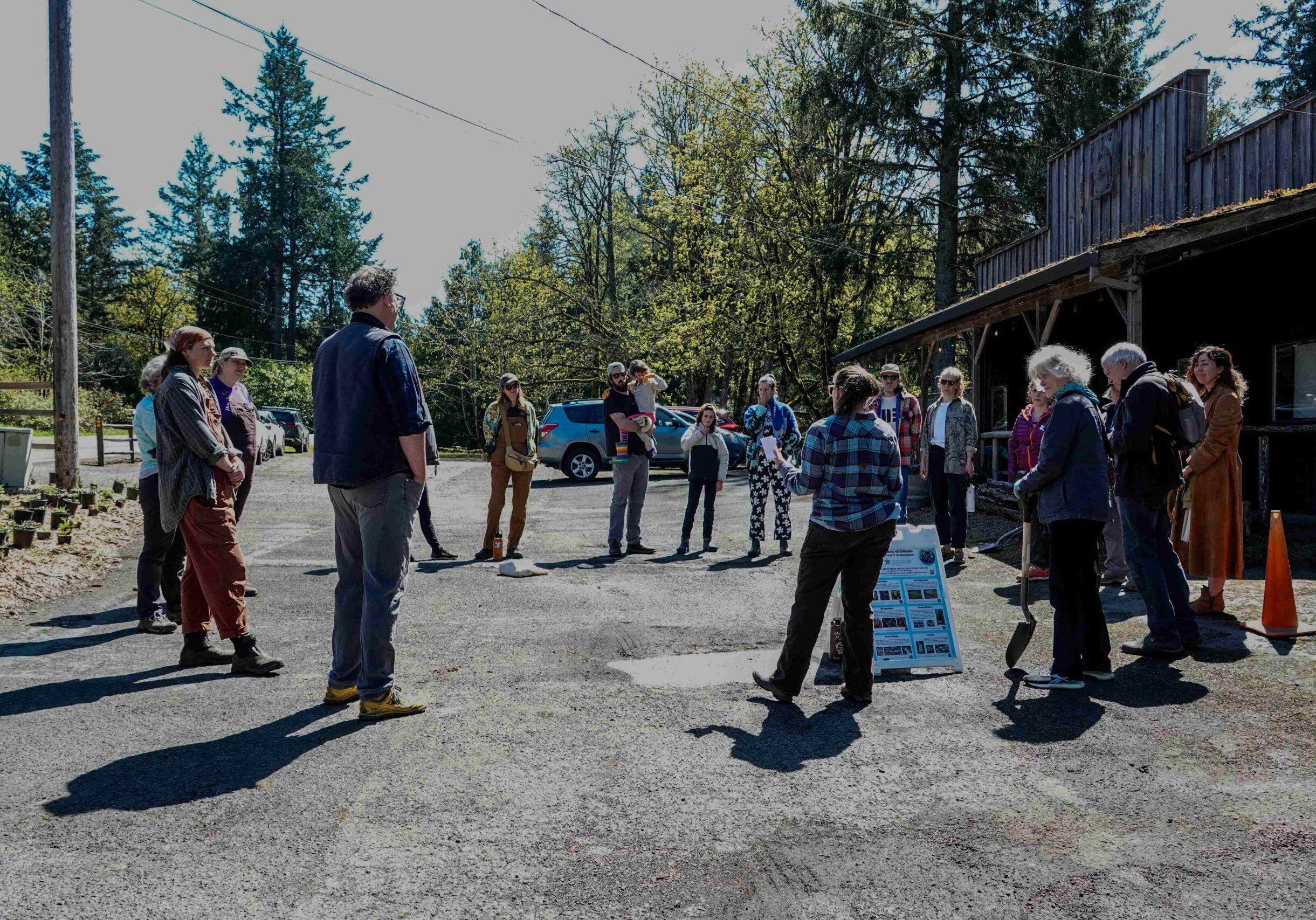 Skyline Tavern 2025 (Rich Kolbell) 19 A huddle up of volunteers in a parking lot with trees in the background.