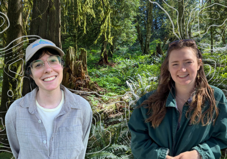 Two smiling women in front of a forested background
