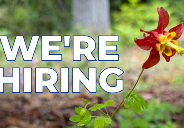 text says we're hiring over a picture of a red and yellow columbine flower